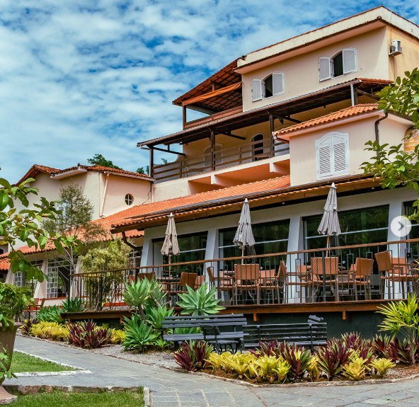 Fachada do Hotel Santa Amália, com varandas e o jardim à frente